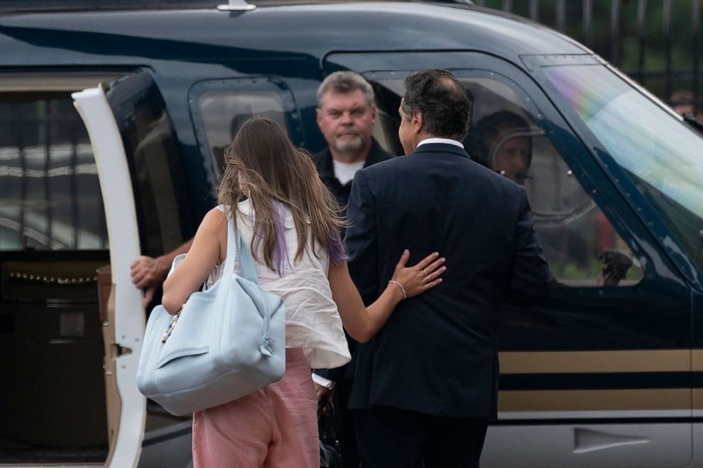 PHOTO: A woman rests her hand on the back of New York Gov. Andrew Cuomo as they take a helicopter flight from a Manhattan heliport, Aug. 10, 2021 in New York.