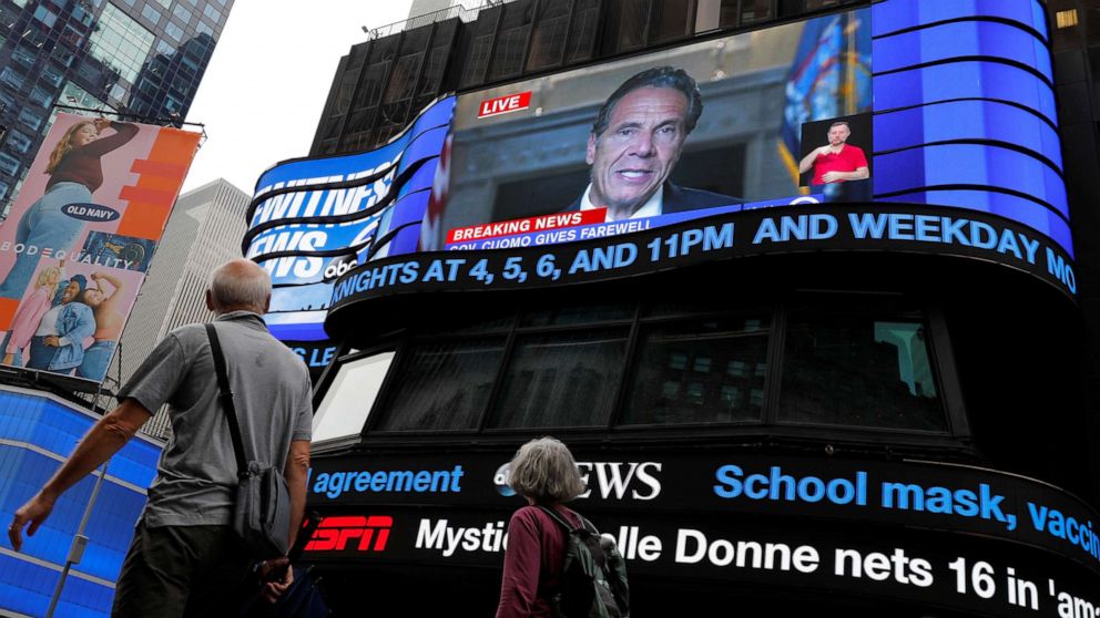 PHOTO: People walk by as a farewell speech by New York Governor Andrew Cuomo is broadcast live on a screen in Times Square on his final day in office in New York City, Aug. 23, 20201.