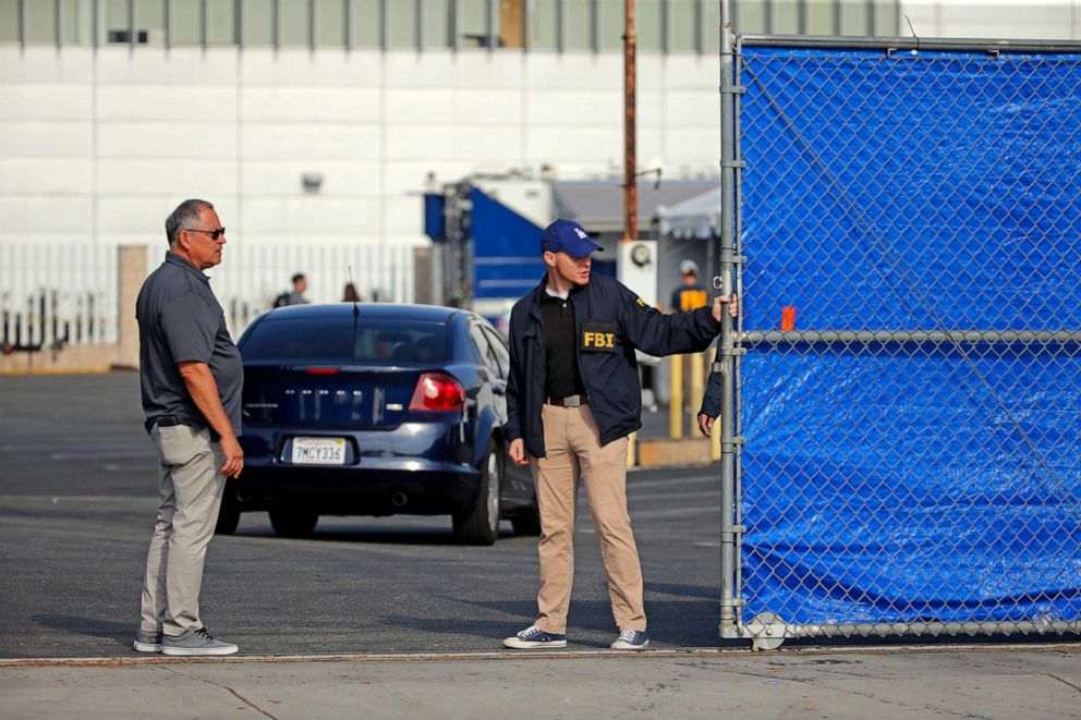 PHOTO: Federal agents stand in a downtown Los Angeles parking lot after predawn raids in the L.A. area, Aug. 22, 2019.