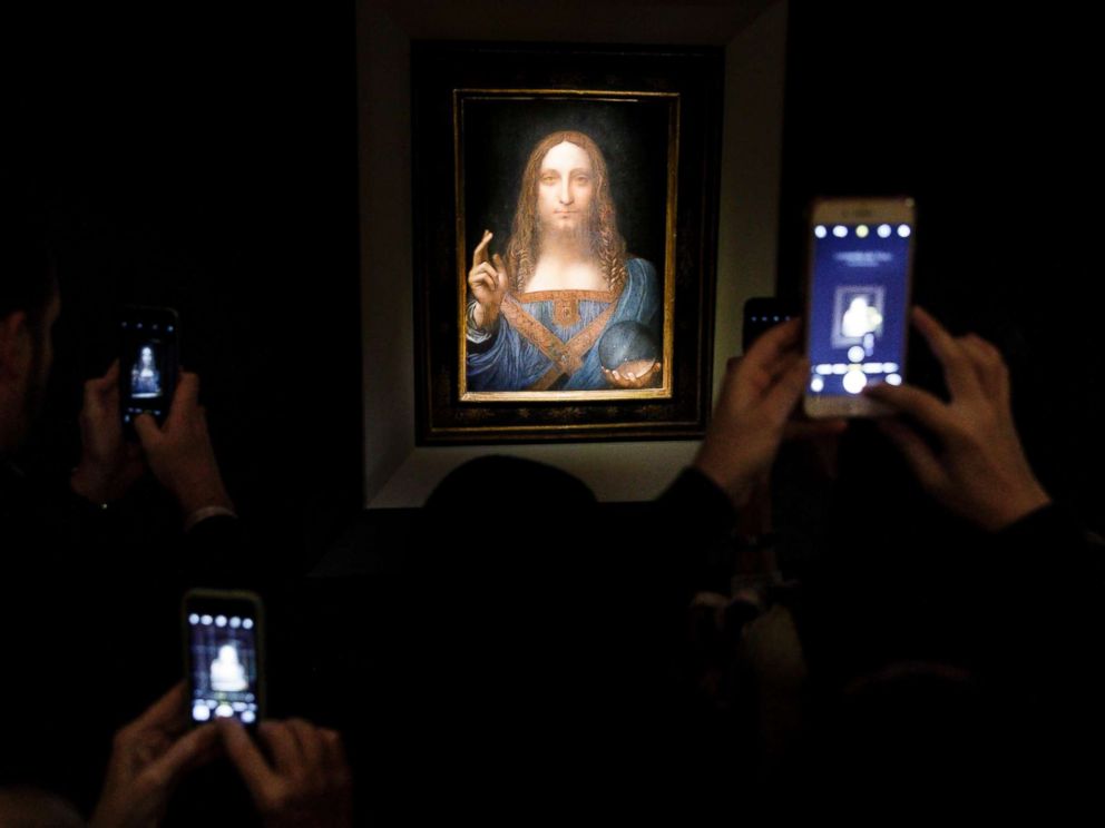PHOTO: People take pictures of the painting Salvator Mundi by Leonardo da Vinci (circa 1500) during a public preview before an auctioning of the painting tonight at Christies auction house in New York, Nov. 15, 2017.