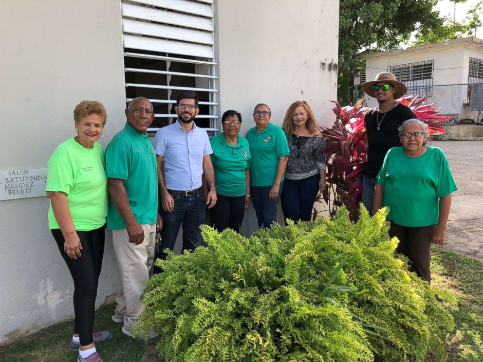 Members of the Social and Cultural Development Committee of Daguao stand alongside a member of the Resilient Power Puerto Rico team.