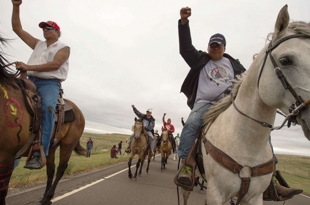 PHOTO: In this Sept. 4, 2016, file photo, Native Americans ride with raised fists to a sacred burial ground that was disturbed by bulldozers building the Dakota Access Pipeline (DAPL), near Cannon Ball, N.D.