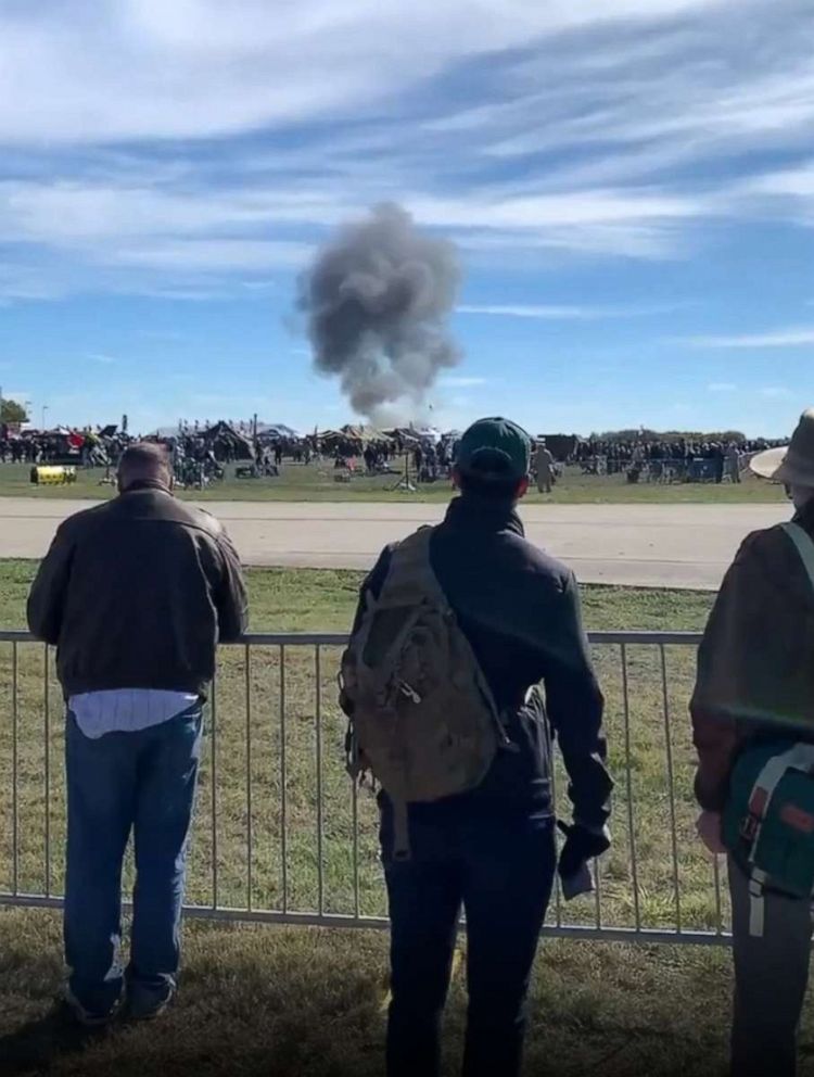 Foto: gli spettatori catturano una nuvola di fumo dopo un incidente durante un'esibizione aerea della seconda guerra mondiale all'aeroporto esecutivo di Dallas il 12 novembre 2022.