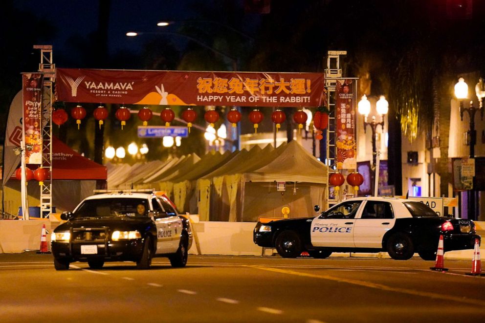 PHOTO: Two police vehicles are seen near a building where a shooting occurred in Monterey Park, Calif., Jan. 22, 2023.