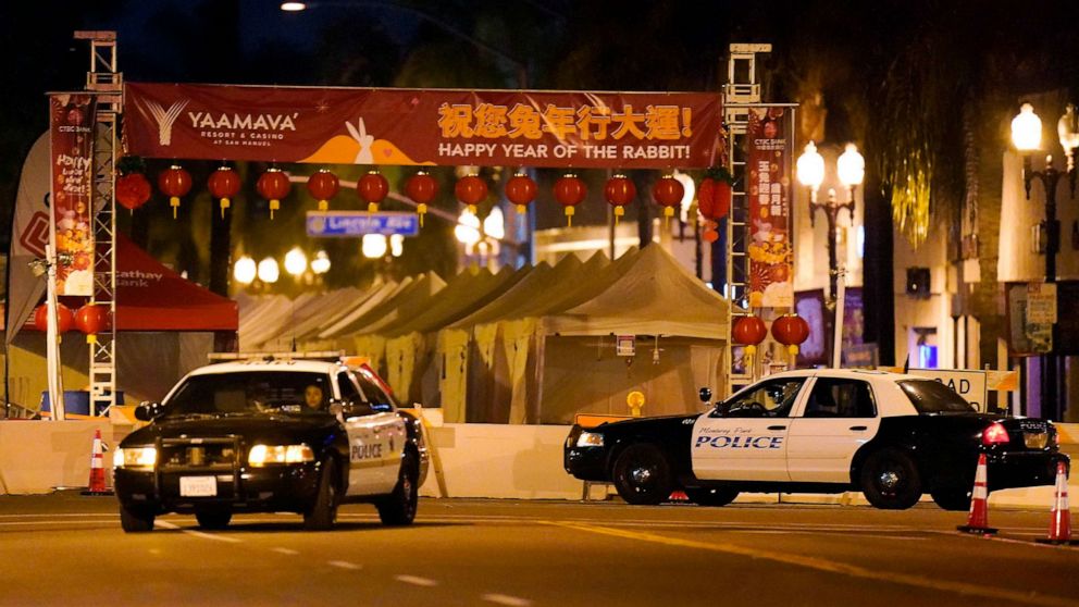 PHOTO: Two police vehicles are seen near a building where a shooting occurred in Monterey Park, Calif., Jan. 22, 2023.