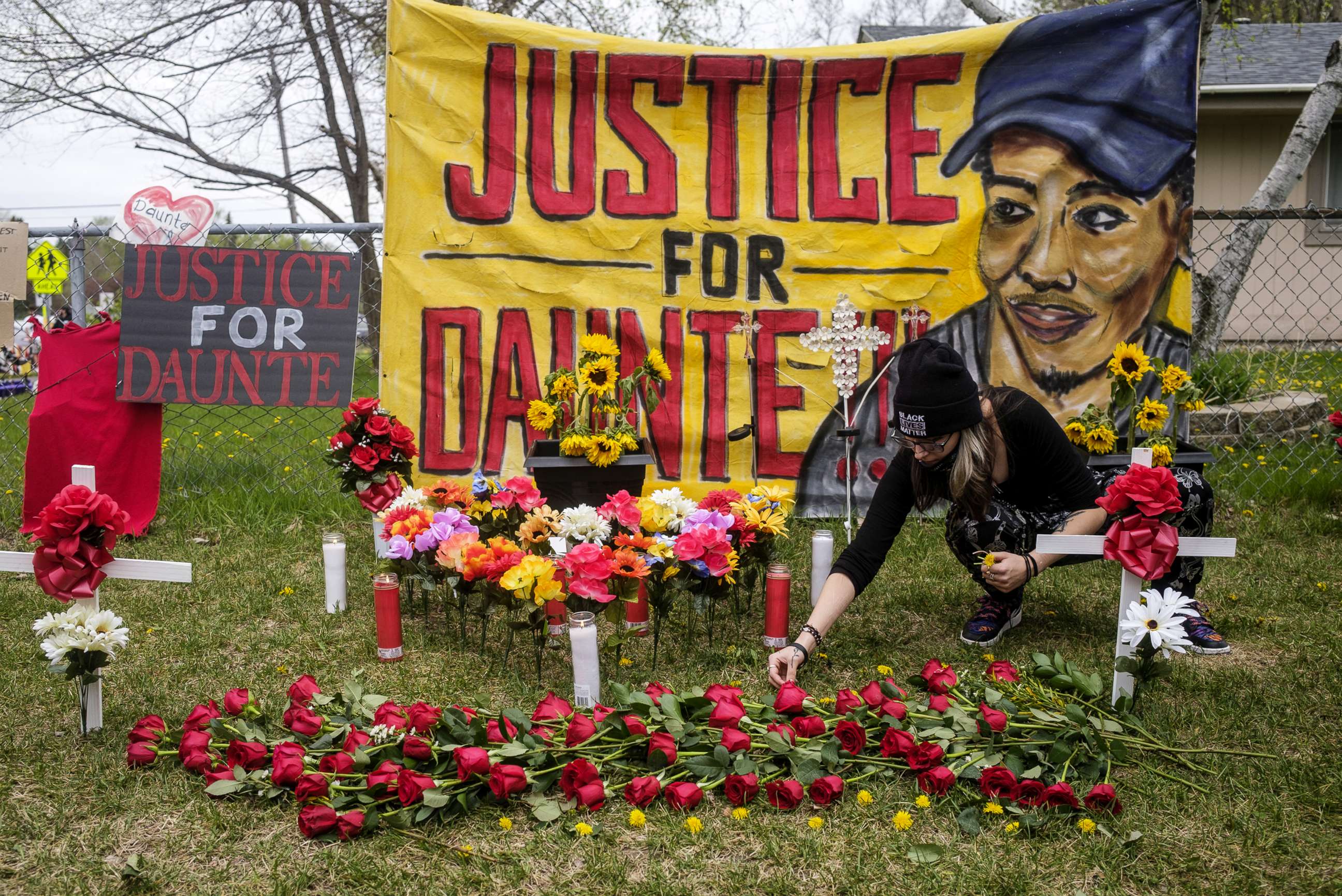 PHOTO: A person decorates a memorial for Daunte Wright with flowers and dandelions in Brooklyn Center, Minn., May 2, 2021.