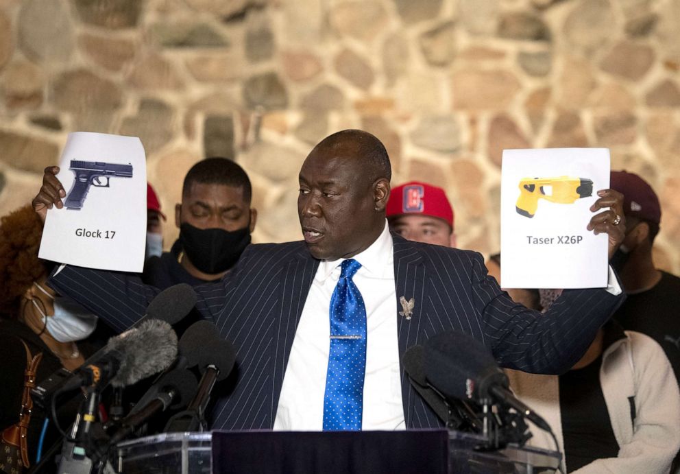 PHOTO: Attorney Ben Crump holds up pictures of a gun and a taser during a press conference with the family of Daunte Wright, on April 15, 2021 in Minneapolis.  Police officer Kim Potter shot and killed Wright during a traffic stop.