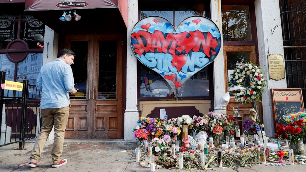 PHOTO: A pedestrian passes a makeshift memorial for the slain and injured victims of a mass shooting that occurred in the Oregon District early Sunday morning, Wednesday, Aug. 7, 2019, in Dayton, Ohio.