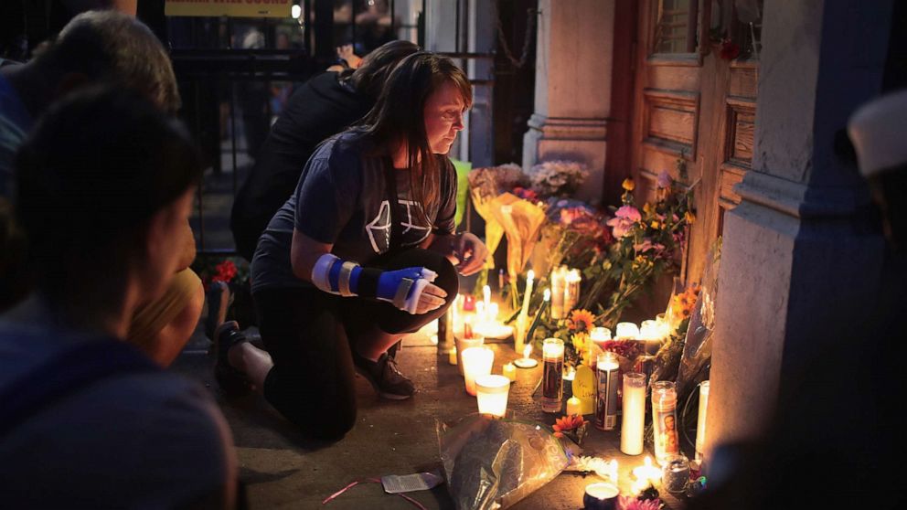 PHOTO: Mourners leave flowers and candles at the entrance of Ned Peppers bar in the Oregon District following a memorial service to recognize the victims of a mass shooting, Aug. 4, 2019, in Dayton, Ohio.
