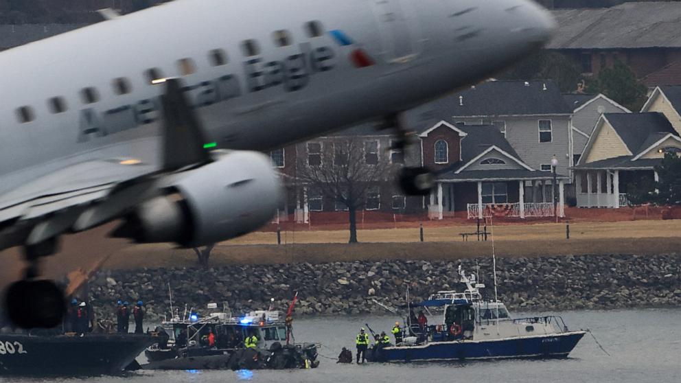 PHOTO: An American Eagle plane departs the Ronald Reagan Washington National Airport, as search and rescue teams work nearby in Arlington, Va., Jan. 31, 2025.