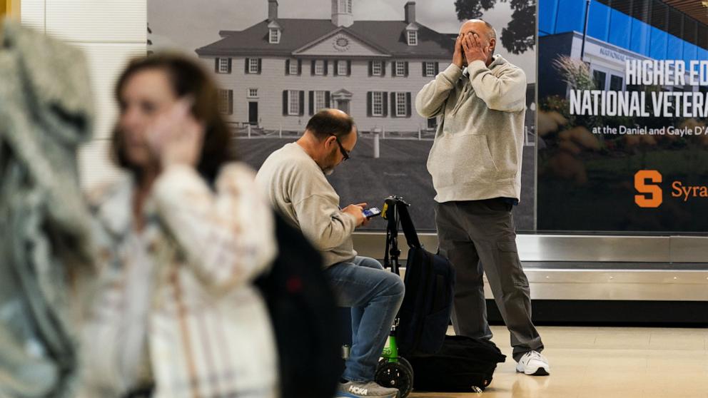 PHOTO: Passengers waiting for baggage at Ronald Reagan National Airport react after the airport was shut down following a collision between a commercial airplane and a military helicopter in Arlington, Va., Jan. 29, 2025.