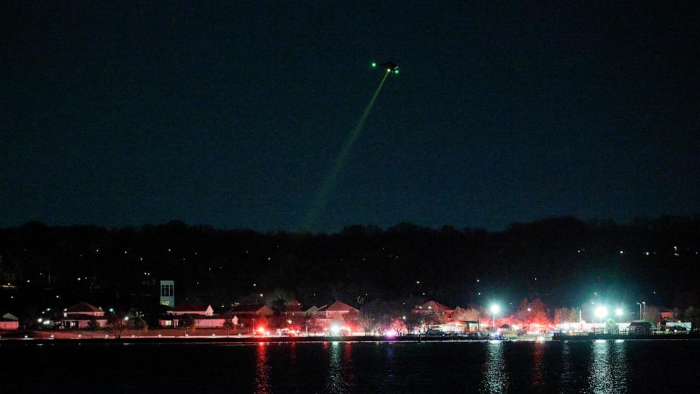 PHOTO: A helicopter assists with search and rescue operations over the Potomac River near Ronald Reagan Washington Airport, Jan. 30, 2025 in Arlington, Va.
