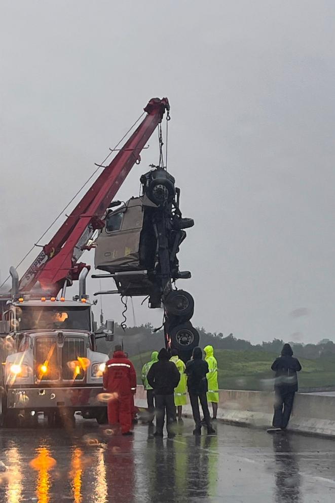 PHOTO: The cab of a tractor trailer is raised from a bridge on Interstate 75 near Tampa, Fla., Aug. 5, 2024, after the truck collided with a concrete wall, flipped over the wall, and was left dangling from the bridge. 