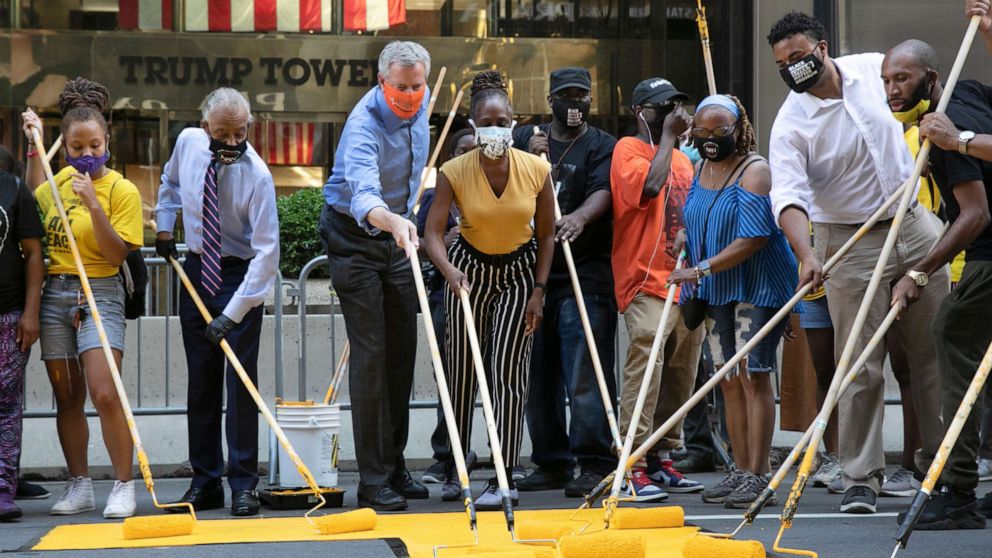 New York City Mayor Bill de Blasio participated in painting the slogan on Fifth Avenue in front of Trump Tower.