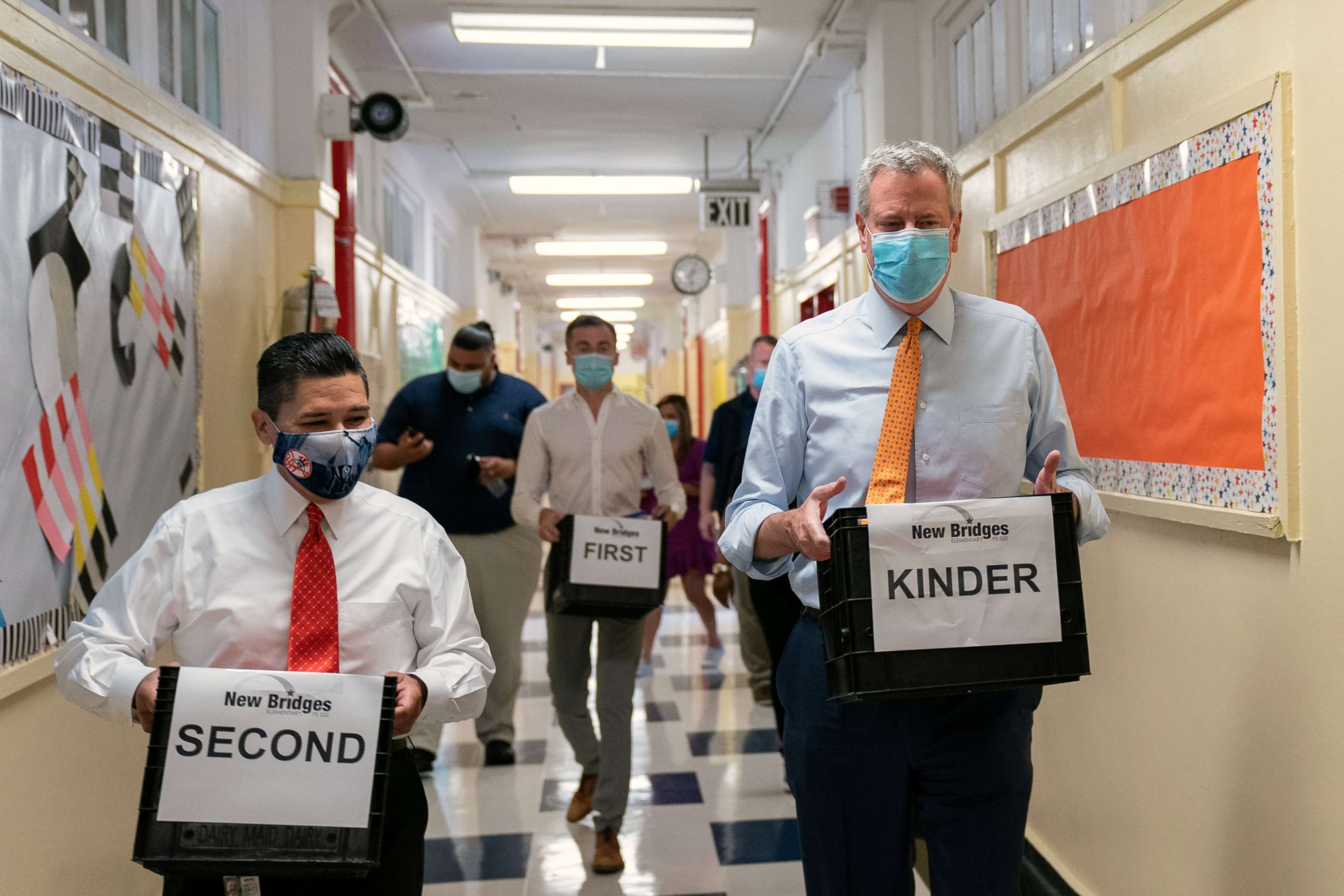 PHOTO: Richard Carranza, chancellor of the New York City Department of Education, left, and New York Mayor Bill de Blasio carry bins with supplies during a news conference at New Bridges Elementary School in Brooklyn, New York, Aug. 19, 2020.