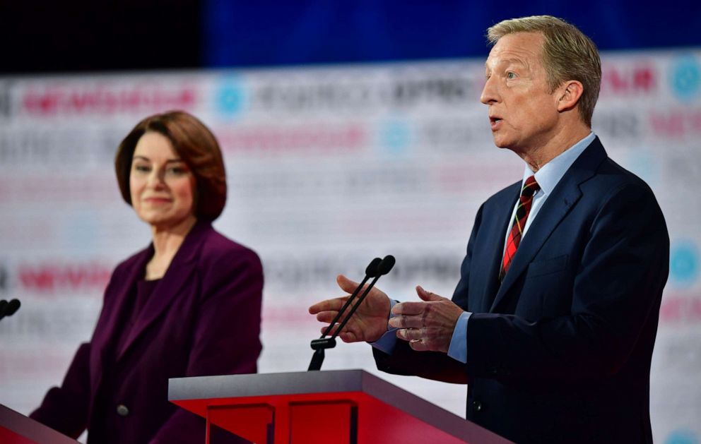 PHOTO: Amy Klobuchar listens to Tom Steyer speak on stage during the sixth Democratic primary debate of the 2020 presidential campaign season co-hosted by PBS NewsHour & Politico at Loyola Marymount University in Los Angeles, California.