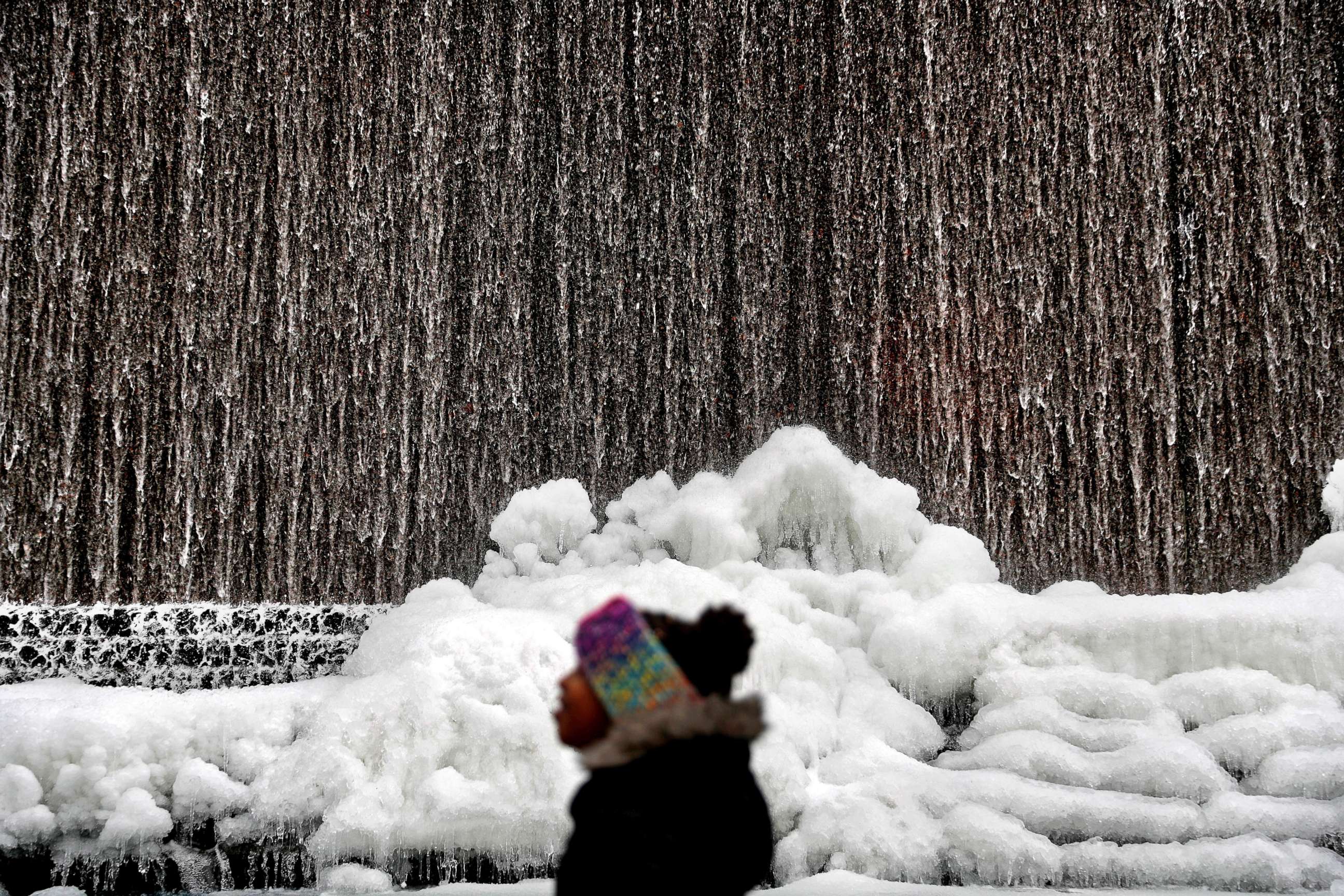 PHOTO: Alora Freeman, 8, watches as ice builds along a downtown water fountain in Atlanta, Jan. 3, 2018.