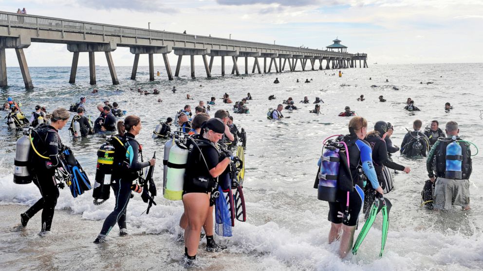 PHOTO: Divers enter the water in an attempt to break the world record for the largest underwater cleanup at the Deerfield Beach International Fishing Pier in Deerfield Beach, Fla., Saturday, June 15, 2019. 