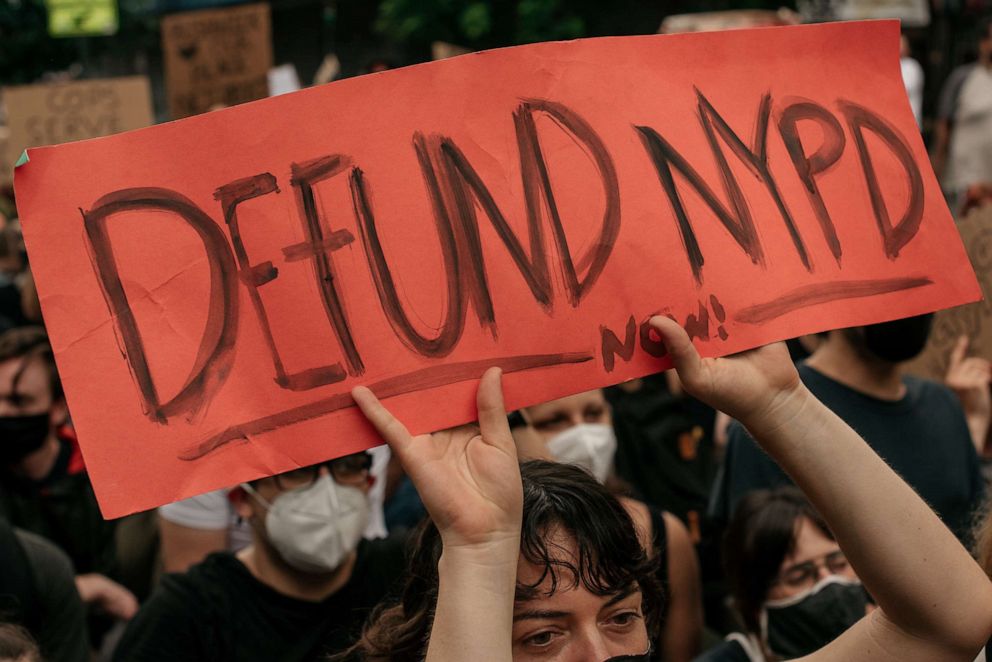 PHOTO: A woman holds a sign calling for the defunding of the NYPD at a march denouncing systemic racism in law enforcement in the borough of Brooklyn on June 5, 2020, in New York City. 