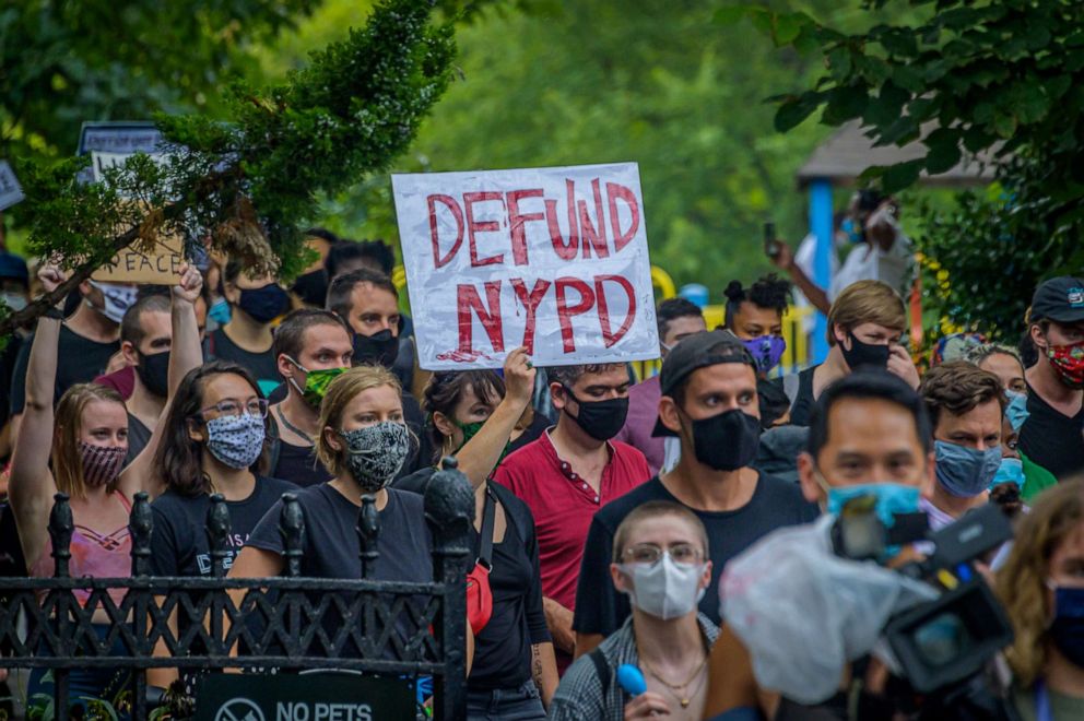 PHOTO: A person holds a "Defund NYPD" sign at a protest in New York on Aug., 28, 2020, in solidarity with the Get Your Knee Off Our Necks Commitment March on Washington, DC.