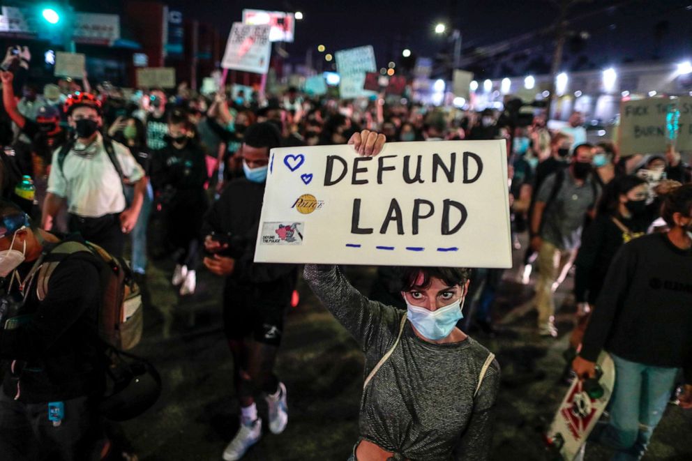 PHOTO: People protesting the Kentucky grand jury decision in the case of Breonna Taylor's death by Louisville police hold a "Defund LAPD" sign in Los Angeles on Sept. 24, 2020.