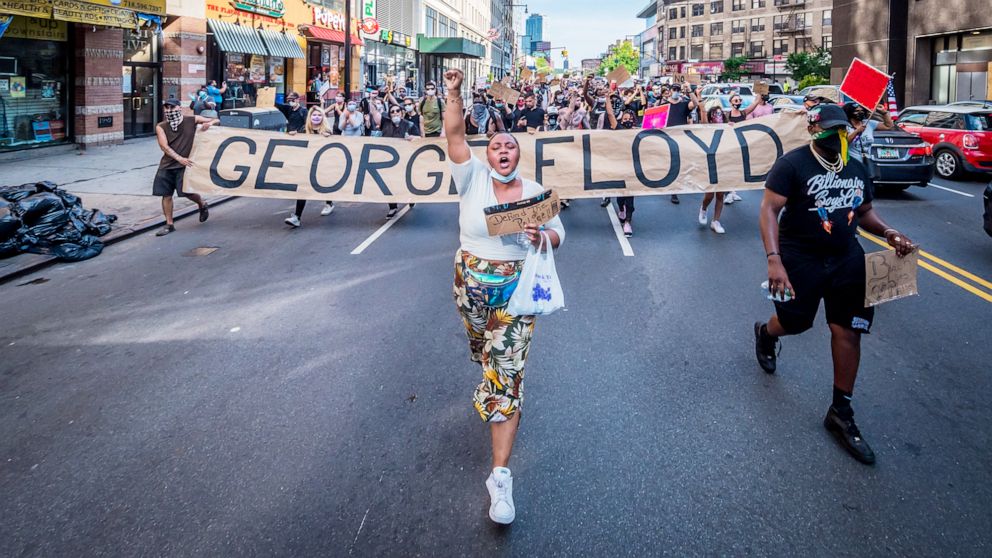 PHOTO:A woman chants "Say His Name" while protesters behind hold a giant banner reading GEORGE FLOYD in Brooklyn, New York, June 4, 2020.