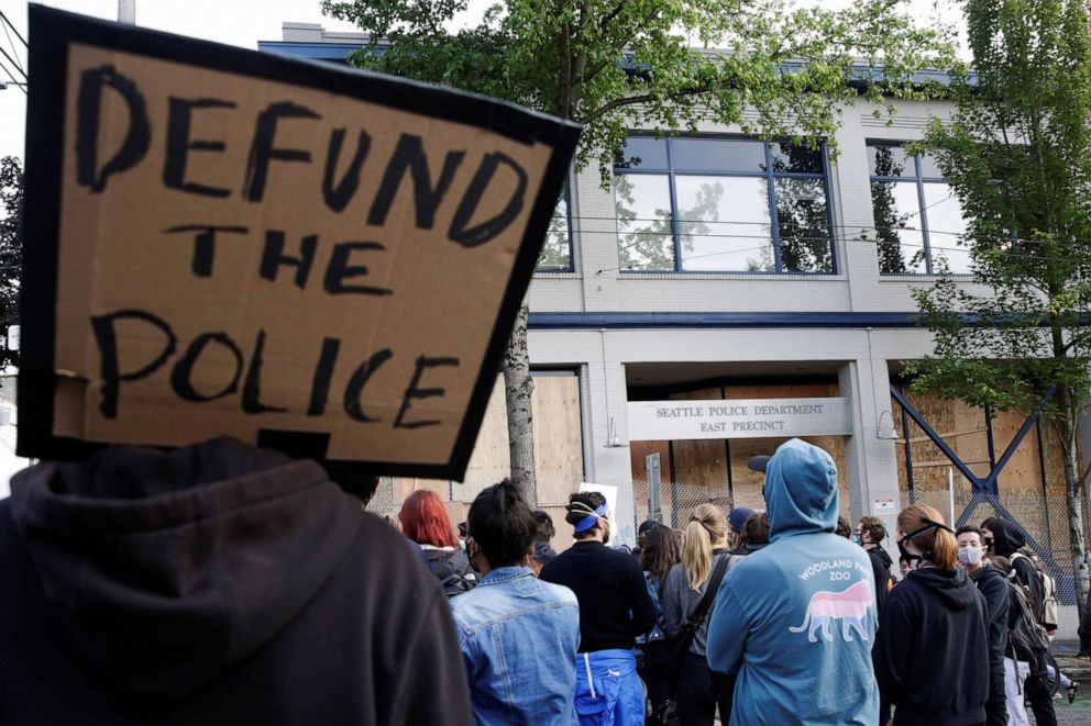 PHOTO: A protester holds a sing that reads "defund the police" as people continue to rally against racial inequality and the death in Minneapolis police custody of George Floyd, in Seattle, June 8, 2020.