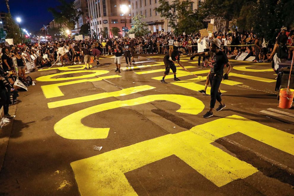 PHOTO: Demonstrators paint the words "defund the police" as they protest Saturday, June 6, 2020, near the White House in Washington, over the death of George Floyd, a black man who was in police custody in Minneapolis. 