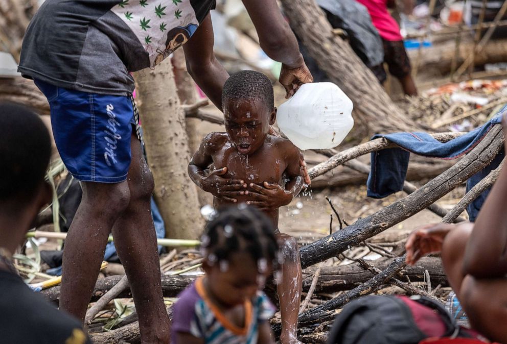 PHOTO: A Haitian immigrant bathes his son in a large migrant camp near an international bridge at the Mexico border, Sept. 21, 2021, in Del Rio, Texas.
