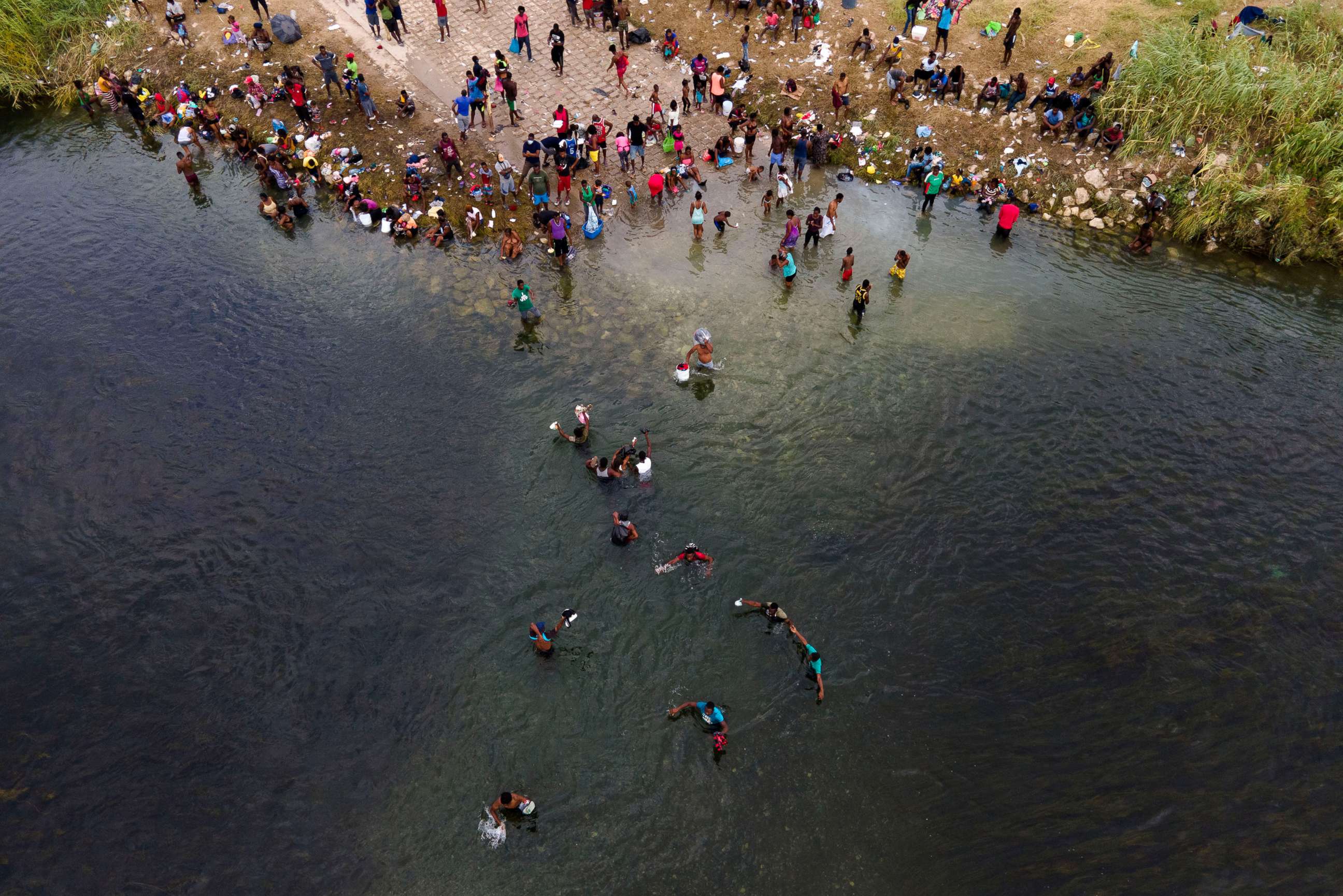 PHOTO: Migrants, many from Haiti, are seen wading between the U.S. and Mexico on the Rio Grande, Sept. 21, 2021, in Del Rio, Texas.