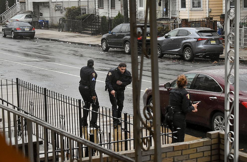 PHOTO: In this Dec. 10, 2019 photo, Jersey City police Sgt. Marjorie Jordan, left, helps fellow officer Raymond Sanchez to safety after he was shot during a gunfight that left multiple dead in Jersey City, N.J.