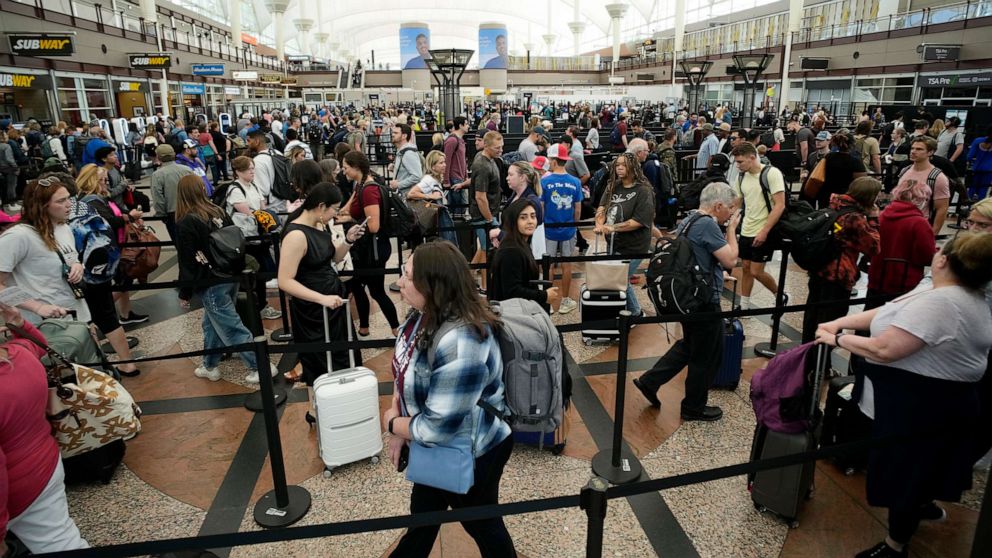 PHOTO: Travelers move through a security checkpoint in Denver International Airport as the summer travel season kicks off with the Memorial Day weekend, May 26, 2023, in Denver.