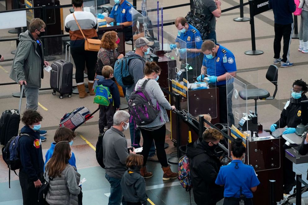 PHOTO: Travelers wear face masks to protect against the novel coronavirus while passing through the south security checkpoint in the main terminal of Denver International Airport in Denver, Colorado, on Dec. 31, 2020.