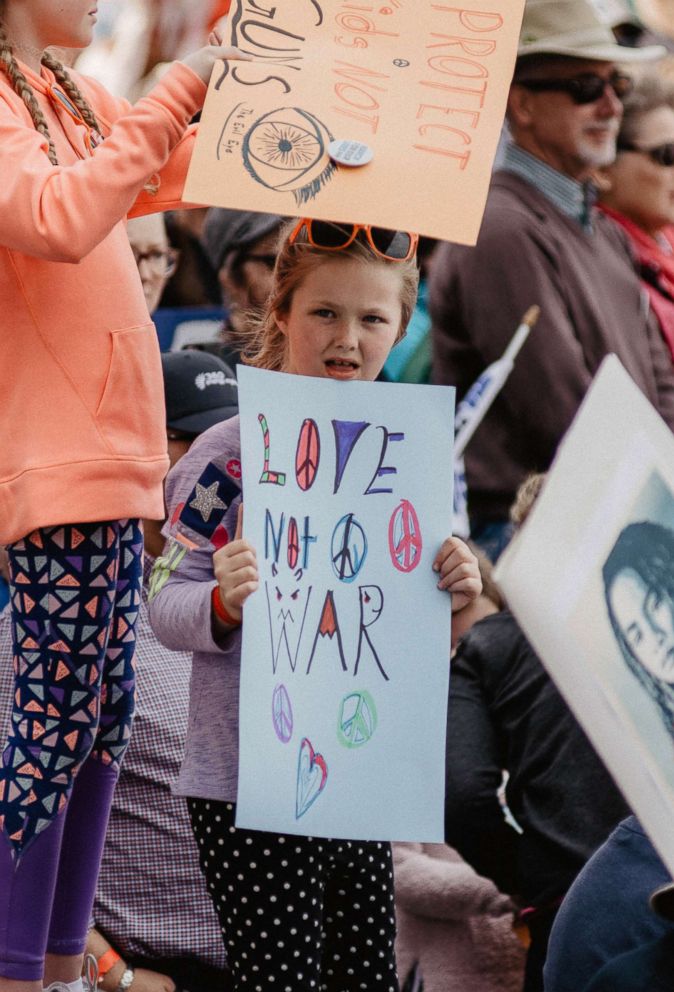 PHOTO: A young girl attending the March for Our Lives event, March 24, 2018, in Denver, holds up a sign reading, "Love not war."