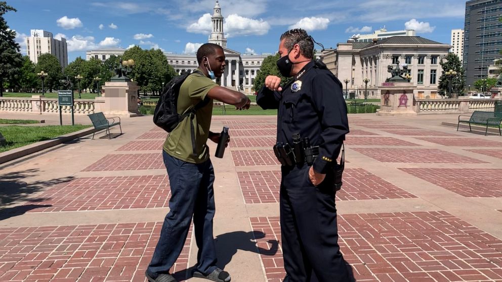 PHOTO: Denver Police Chief Paul Pazen bumps elbows with a protester during a "Justice 4 Floyd" march, May 31, 2020, in Denver, Colorado.