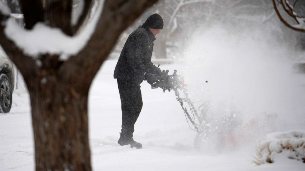 PHOTO: A man uses a snowblower to clear a walkway outside a home after a winter storm packing single-digit temperatures combined with a light snow crossed over the intermountain West Wednesday, Feb. 15, 2023, in Denver.