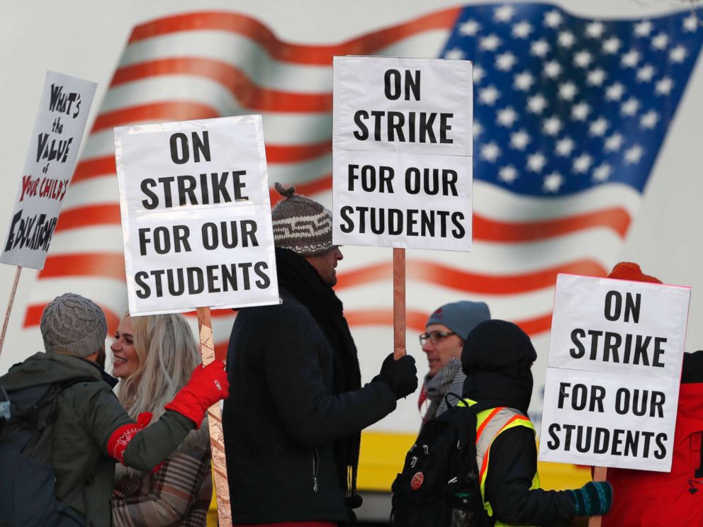 PHOTO: Teachers carry placards as they walk a picket line outside South High School, Feb. 11, 2019, in Denver.