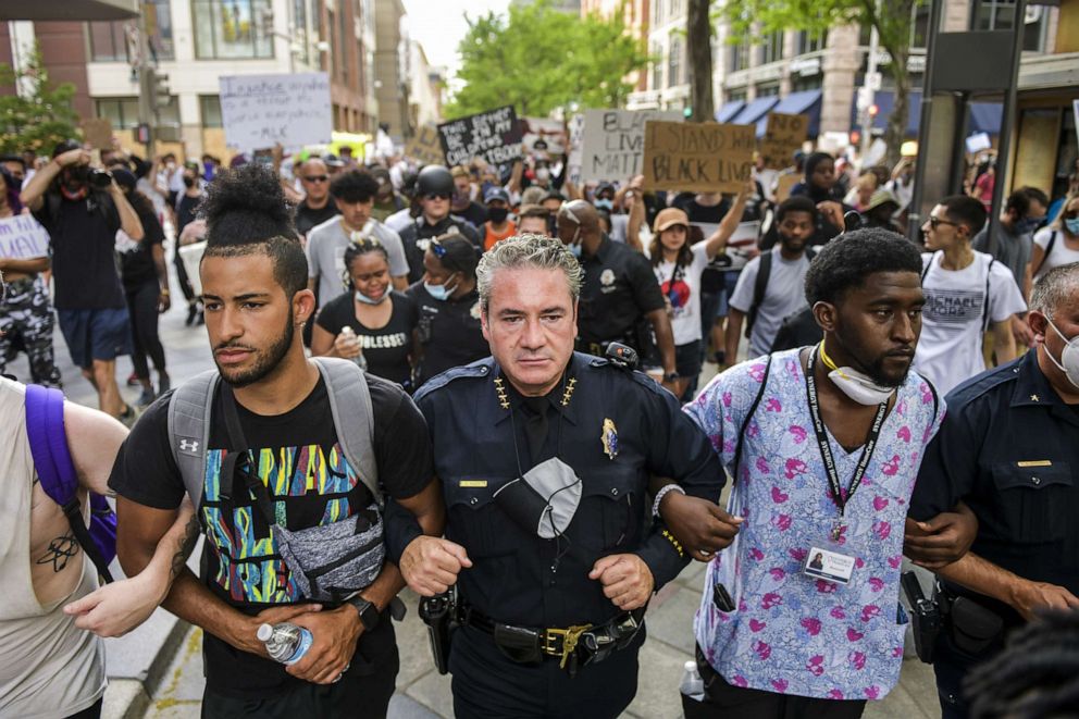 PHOTO: Denver Police Chief Paul Pazen links arms with people protesting the death of George Floyd on June 1, 2020 in Denver.