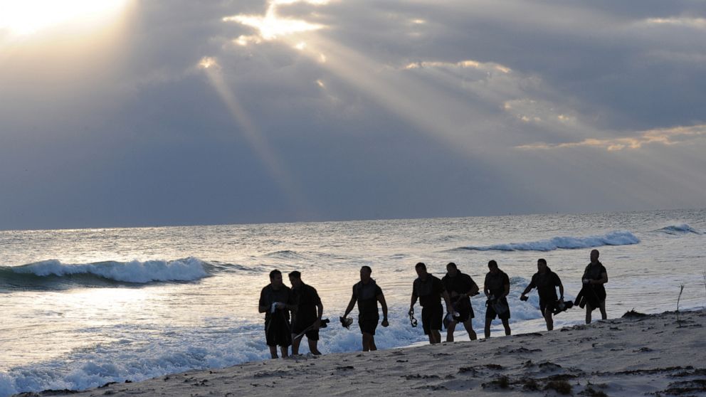 PHOTO: Members of SEAL Team 18 swim into the ocean to release the ashes of fellow SEALs who have died within the last year during a ceremony at Fort Pierce Beach, Fla., Nov. 7, 2010.