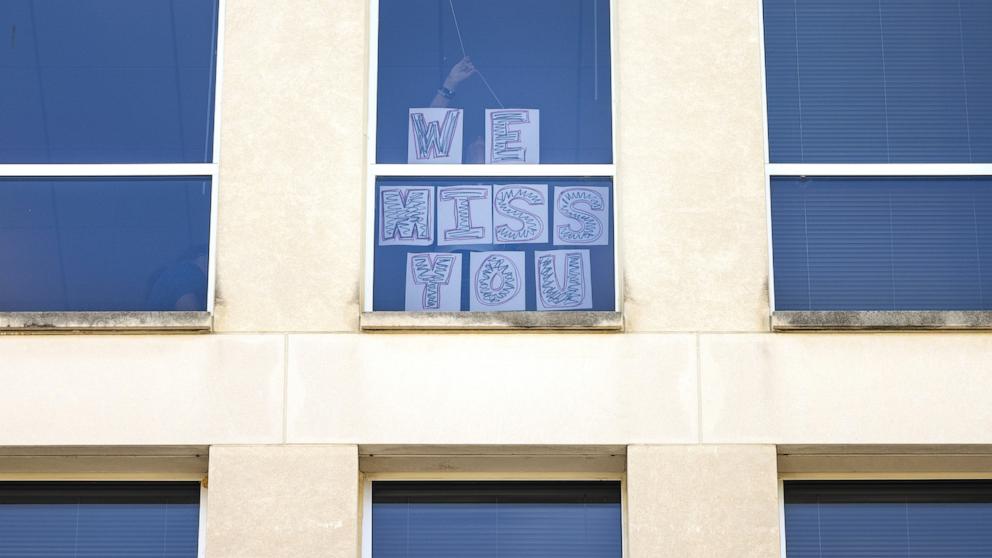 PHOTO: A 'we miss you' sign is taped to a window at the Department of Education as fired employees, along with other civil servants, rally in support of the department in Washington, Mar. 11, 2025