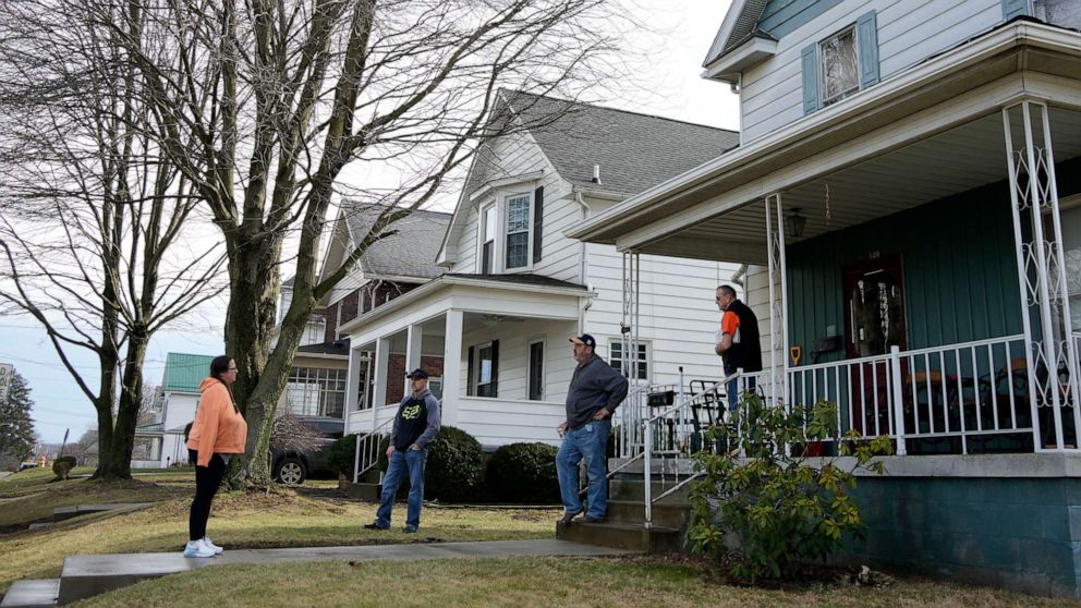 PHOTO: Neighbors gather outside a home as residents were allowed back in their homes after a derailment of a Norfolk Southern freight train in East Palestine, Pa, Feb. 9, 2023.