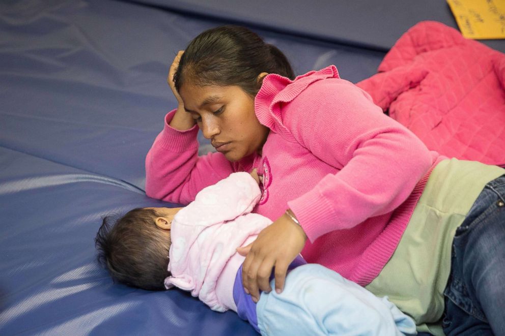 PHOTO: A Guatemalan woman and her infant daughter seeking asylum pass time at a Catholic Charities relief center on June 17, 2018, in McAllen, Texas.
