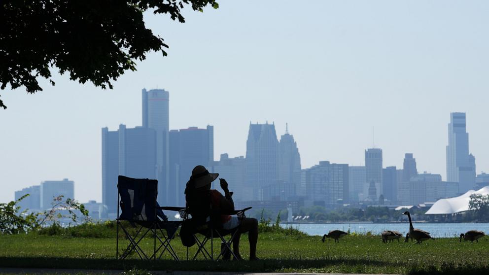 PHOTO: A woman sits in the shade to avoid the heat Monday, July 13, 2026, in Detroit. 