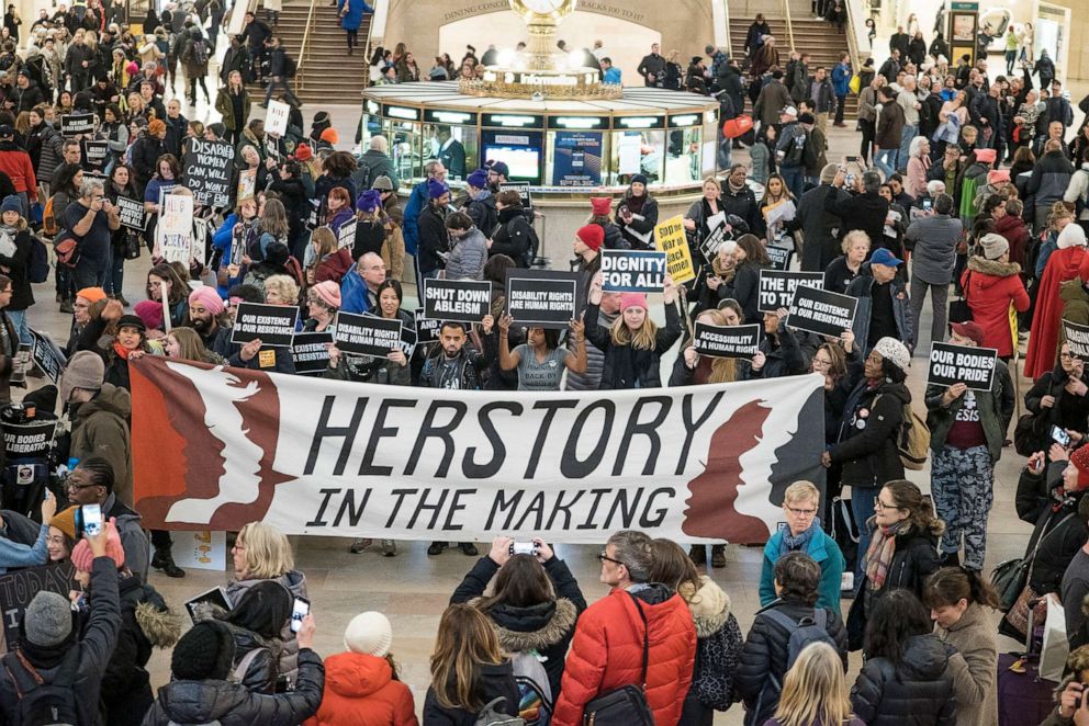 PHOTO: Demonstrators gather during the Non-March For Disabled Women inside Grand Central Station, New York, Jan. 19, 2019. At center is large banner that reads 'Herstory in the Making' while another visible signs are ones that read   'Shut Down Ableism'.