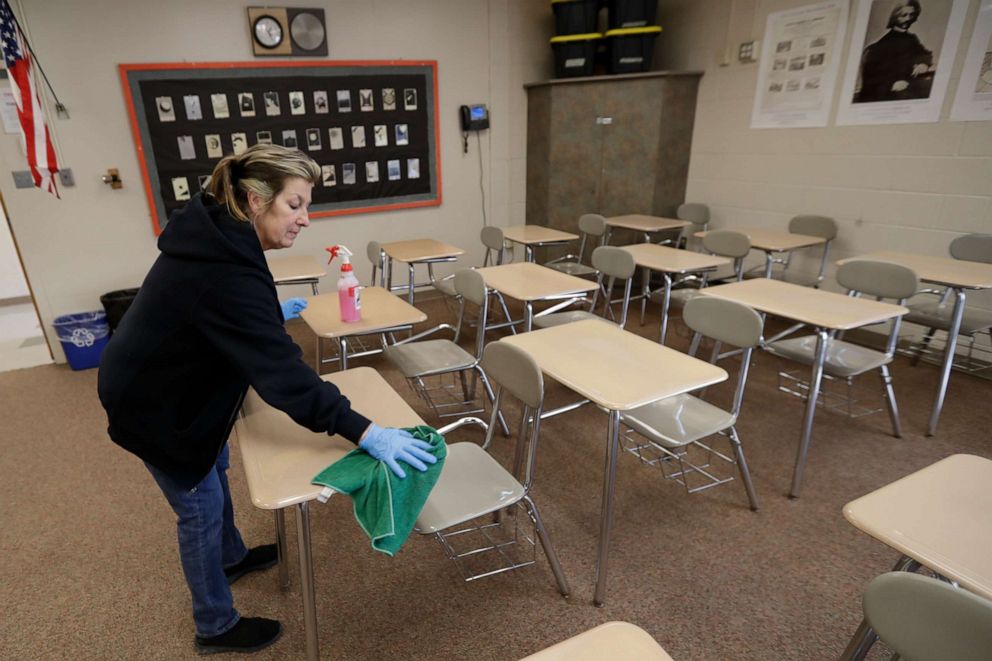 PHOTO: Custodian Patti Alesci cleans desks at Orange High School in Pepper Pike, Ohio, on March 16, 2020.