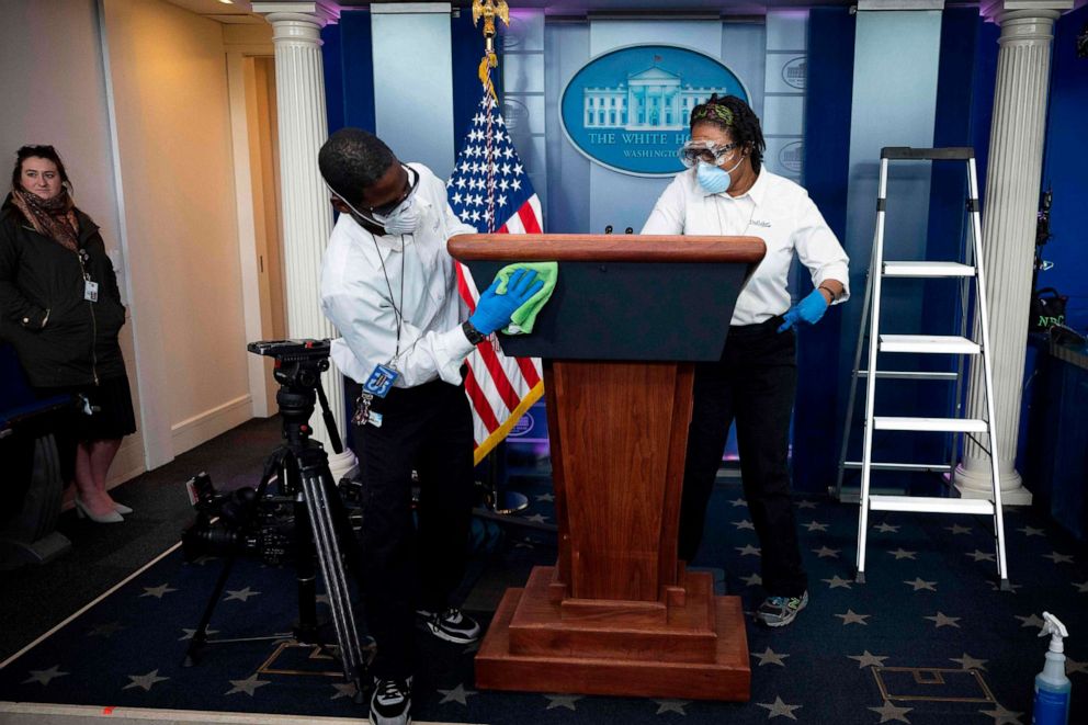PHOTO: Cleaning staff disinfect the lectern in the Brady Press Briefing Room ahead of the Coronavirus Task Force press briefing at the White House in Washington, D.C., on April 9, 2020.