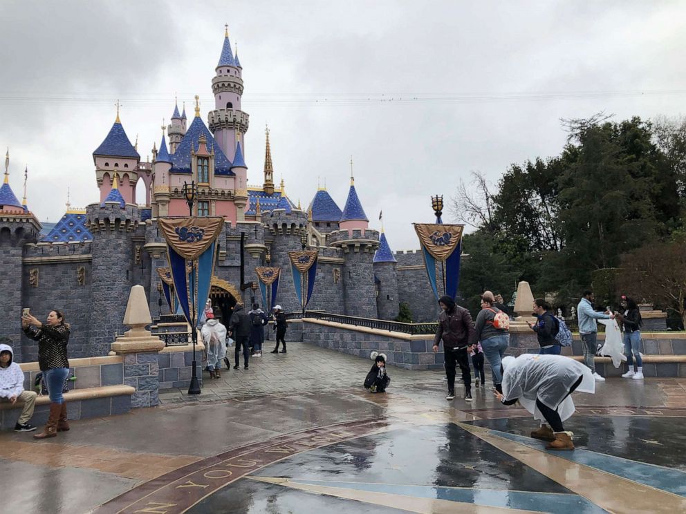 PHOTO: In this March 13, 2020, file photo, visitors take photos at Disneyland in Anaheim, Calif. 