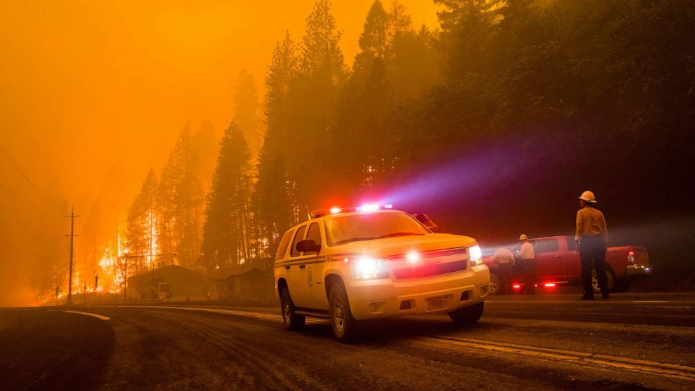 PHOTO: Firefighters turn their cars around as active flames reach highway 70, July 24, 2021. The Dixie fire continues to burn in California burning over 180,000 acres with 20% containment.
