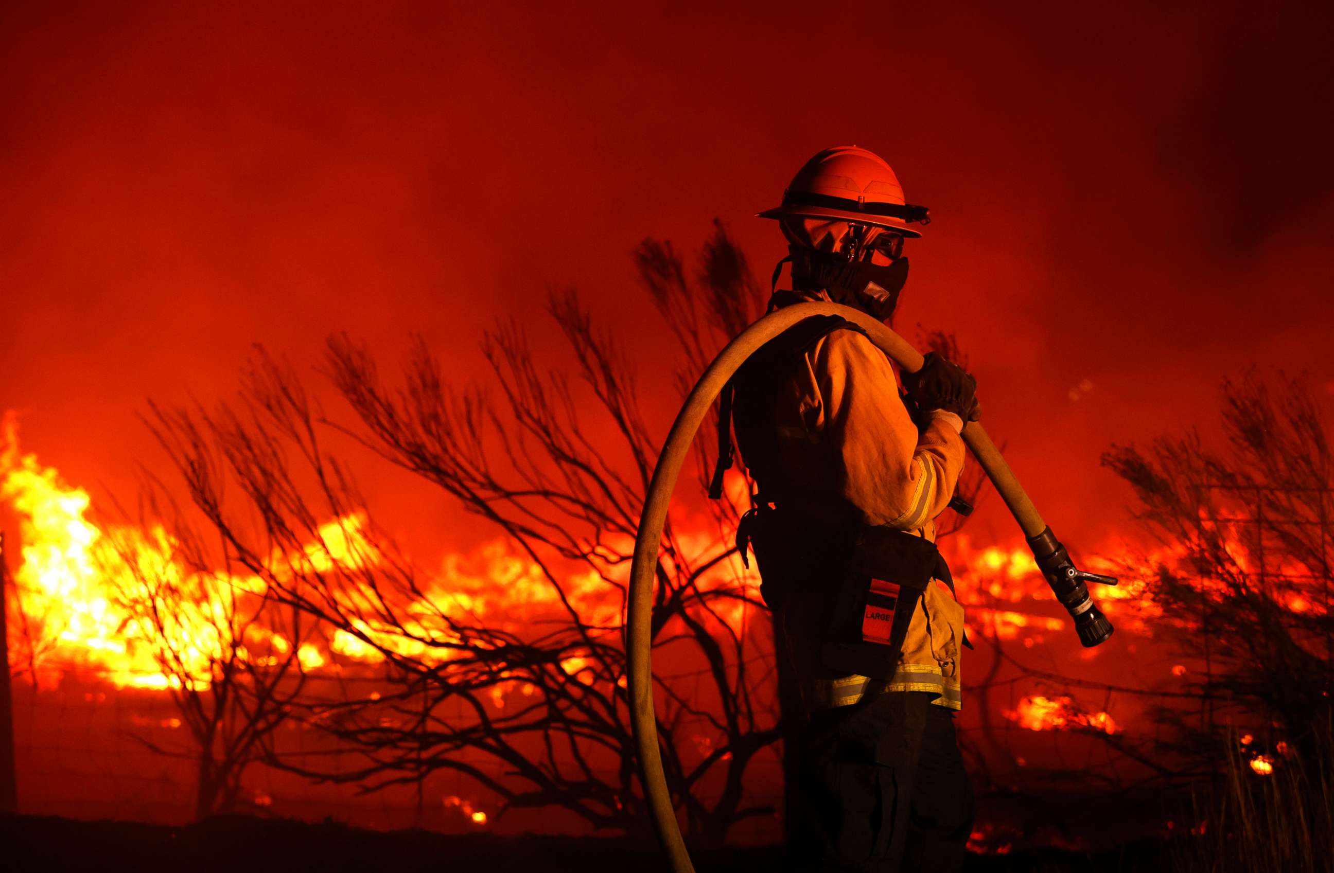 PHOTO: A firefighter monitors the Dixie Fire as it burns close to a home on Aug. 16, 2021, near Janesville, Calif.