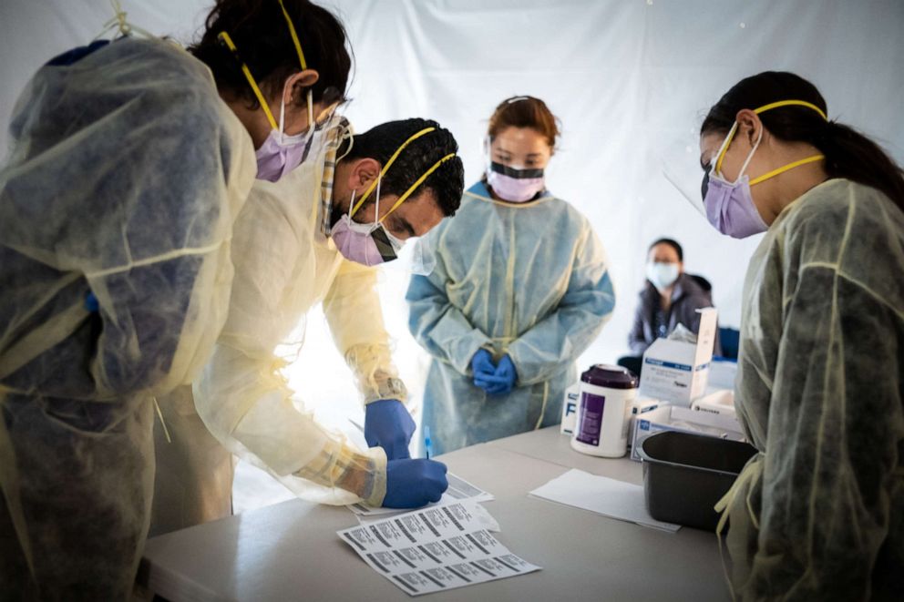 PHOTO: Doctors test hospital staff with flu-like symptoms for coronavirus (COVID-19) in set-up tents to triage possible COVID-19 patients.